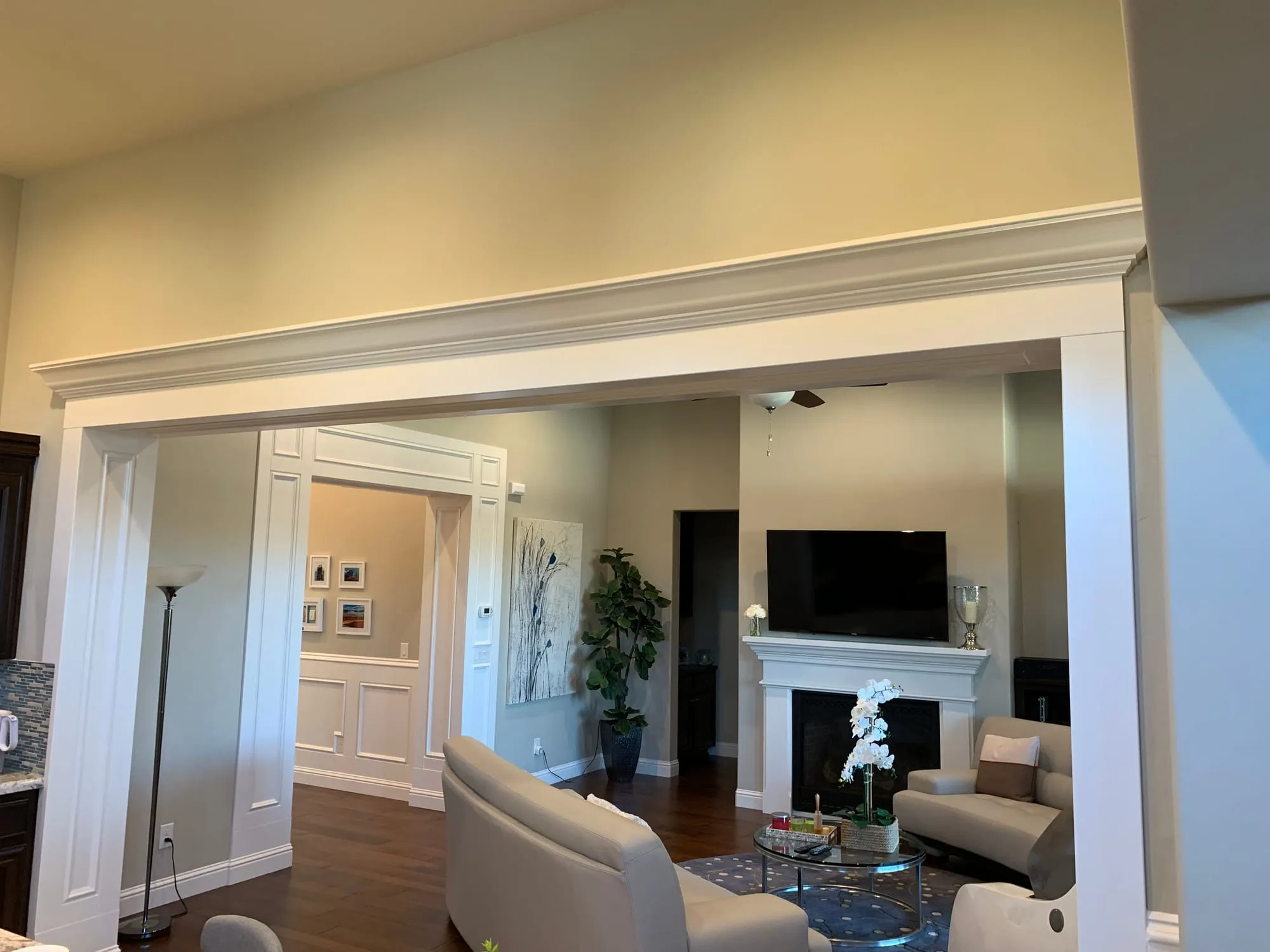 Living room with custom cased opening, wainscoting and crown molding